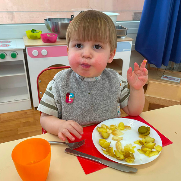 Un enfant savourant sa raclette avec un grand sourire.