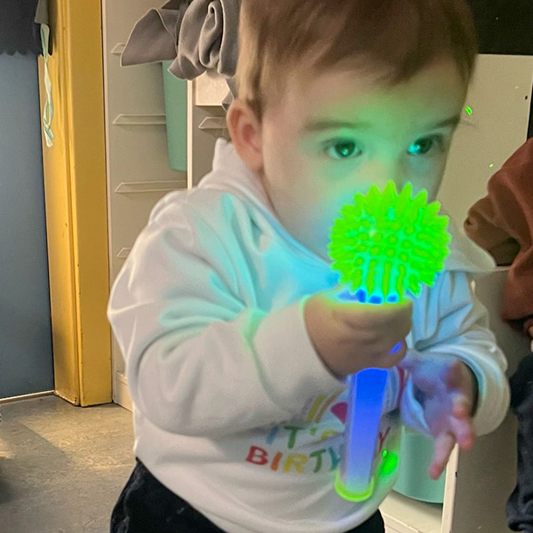 Enfant observant un jouet sensoriel lumineux vert