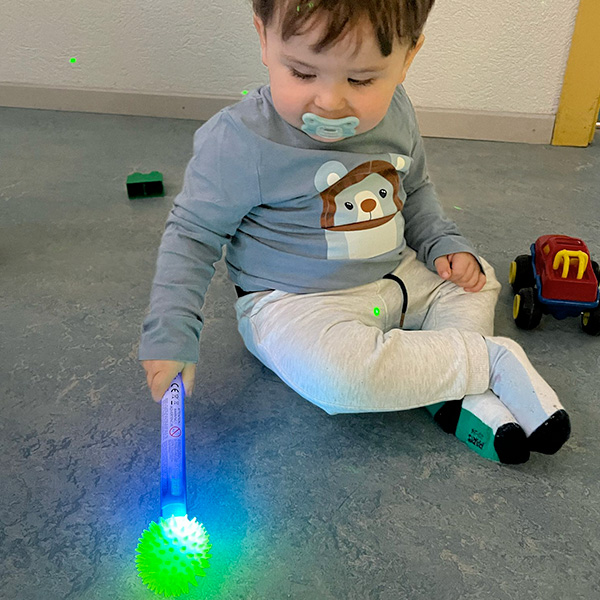 Petit garçon jouant avec une balle lumineuse verte