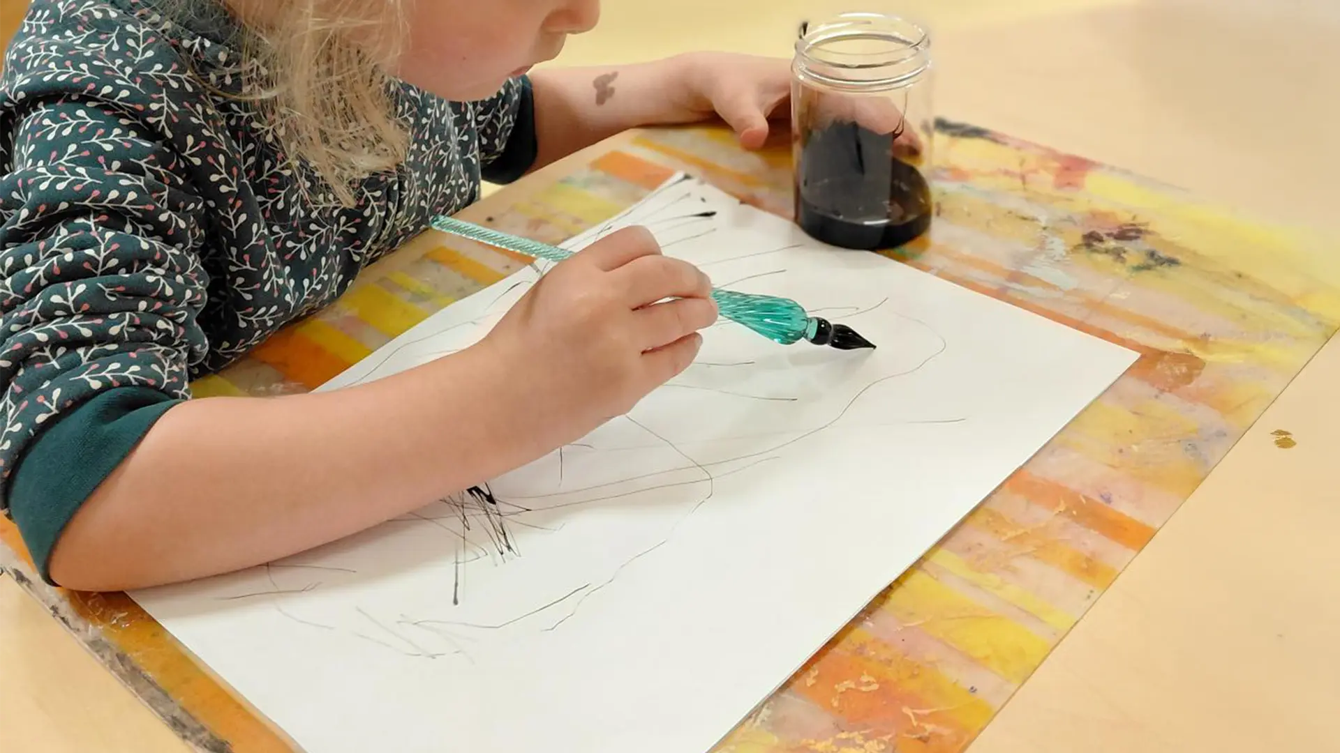 Enfants de la crèche Les Petits Acrobates à Lausanne utilisant l’encre de Chine pour dessiner et découvrir une technique artistique ancestrale.